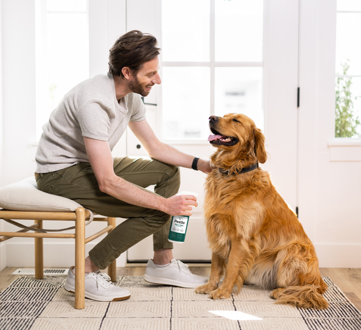 Happy dog being sprayed with Pestie's Flea and Tick Treatment for Pets.