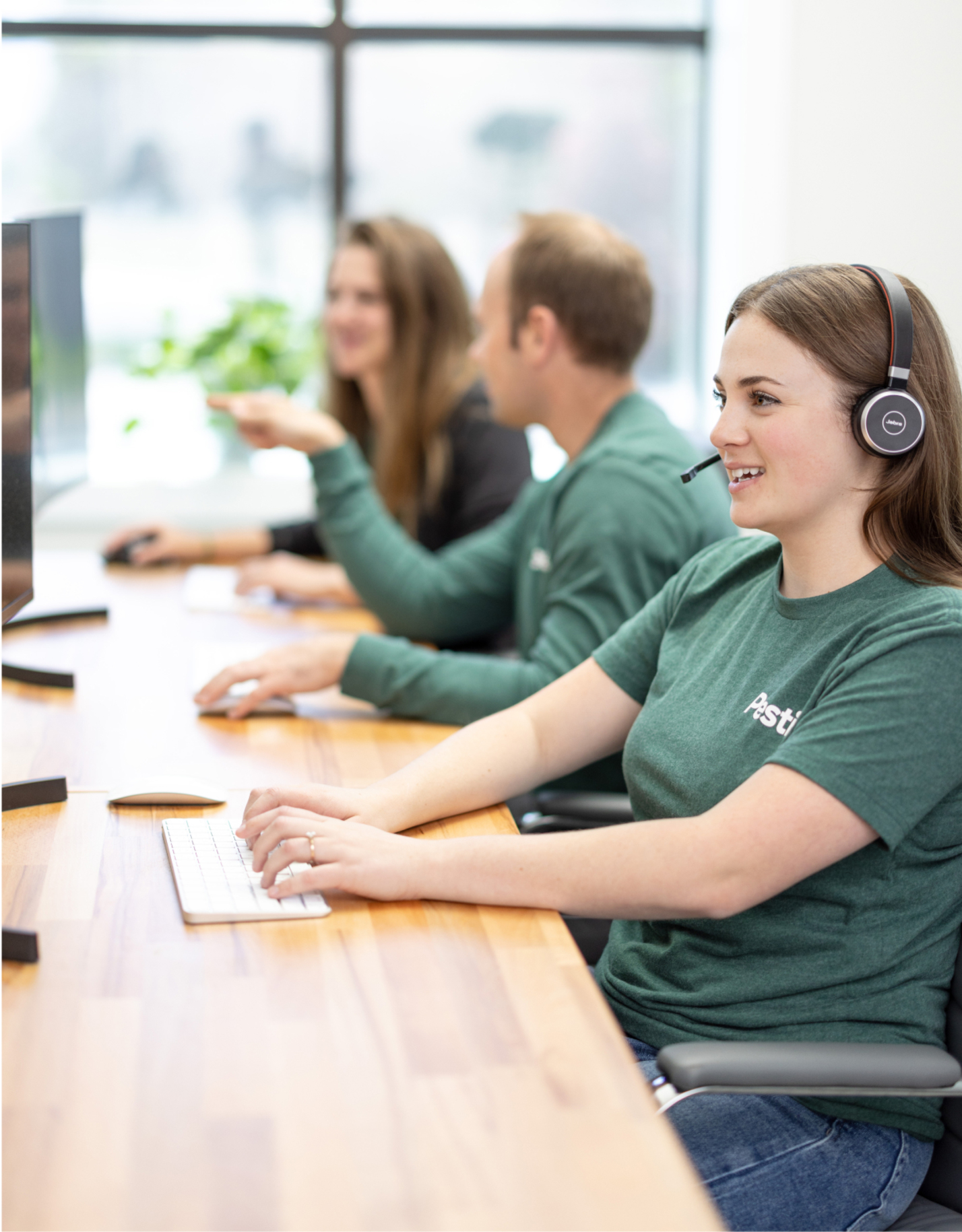 A row of desks with customer service agents working on computers.