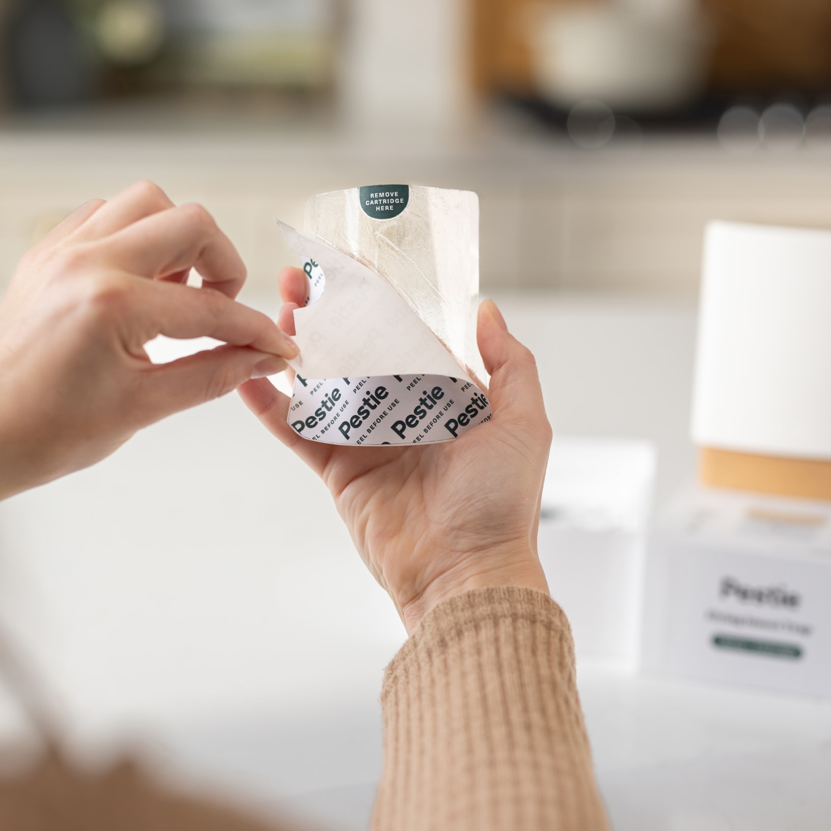 Woman opening the refill cartridge of Pestie's Flying Insect Trap.
