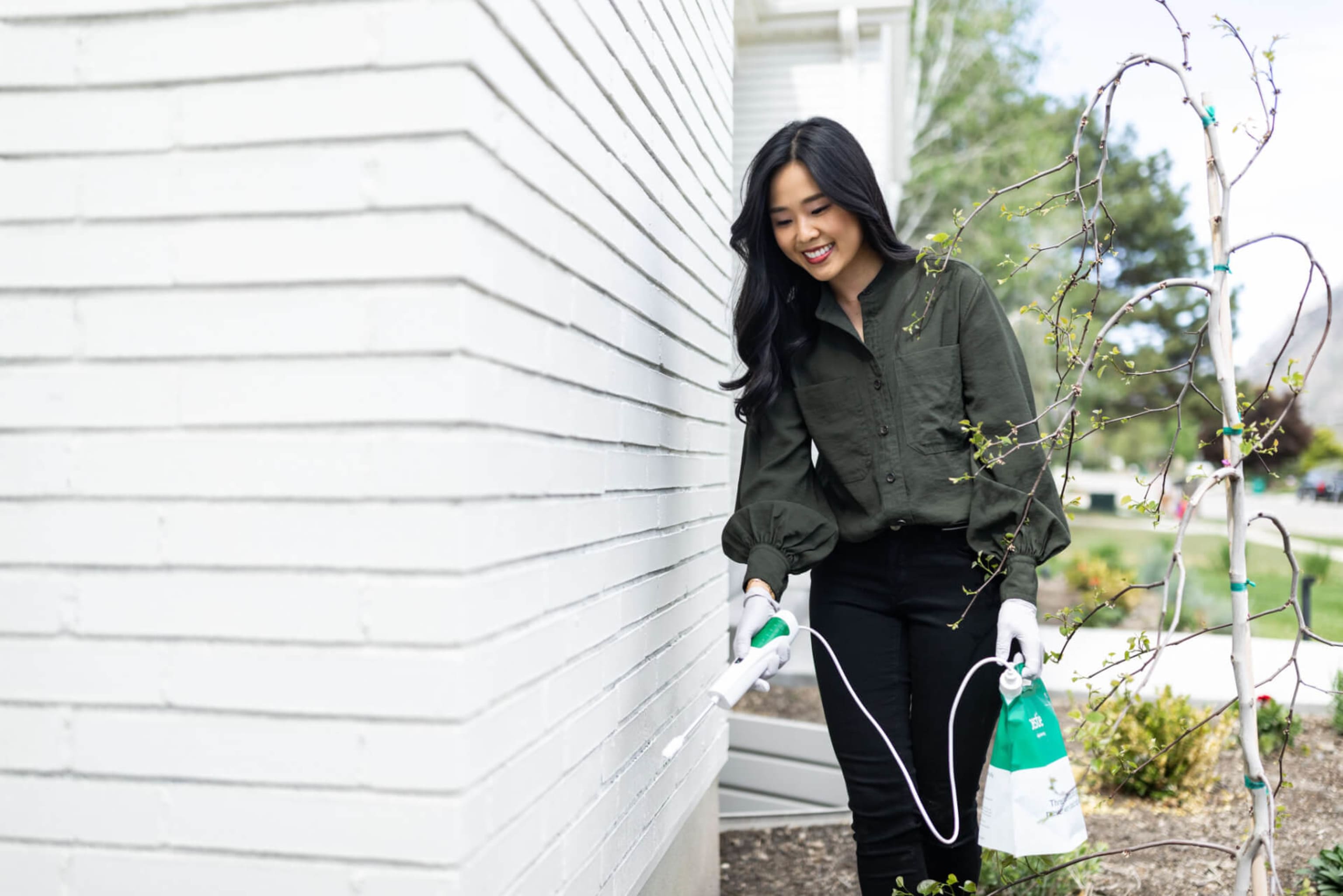 Woman spraying Pestie on a white wall