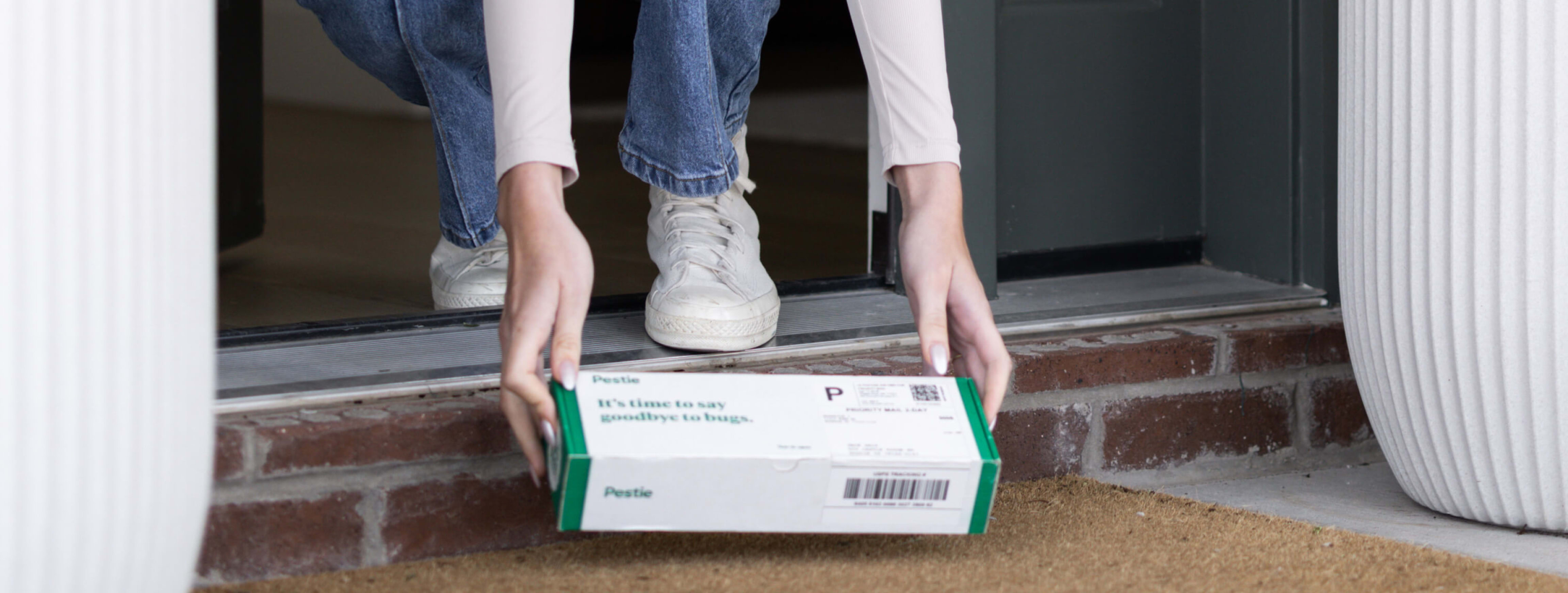 Woman picking up box on doorstep